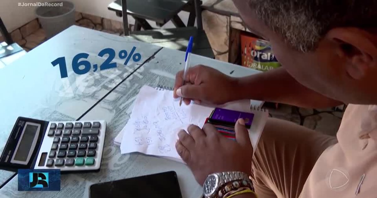 Cobradora de ônibus segurando faturas de cartão de crédito e olhando preocupada