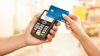 Empreendedor segurando cartão de crédito e analisando documentos financeiros em pequena empresa