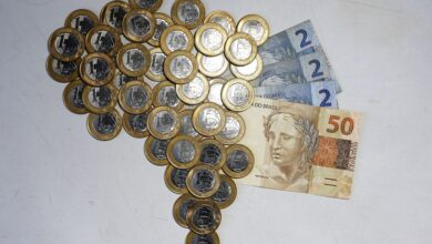 Pessoa analisando investimentos com gráficos, notas de real e destaque para 13,75% representando Selic alta