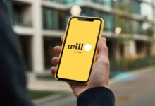 Smartphone exibindo aviso de liquidação do Will Bank com prédio institucional desfocado ao fundo