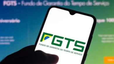 Trabalhador brasileiro checando celular e calendário com documentos do FGTS em 2026