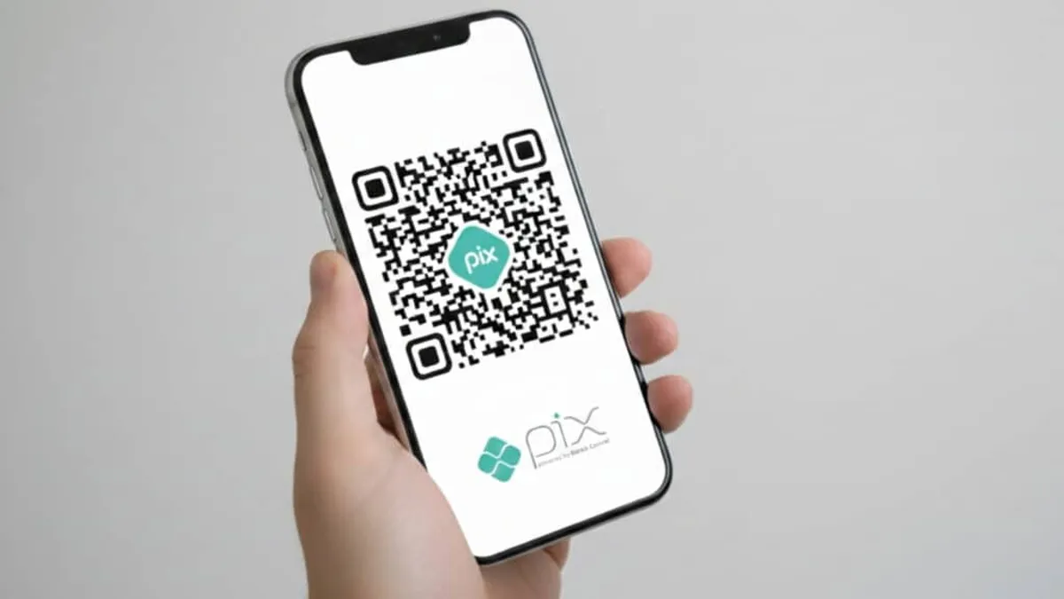 Smartphone exibindo lista de pagamentos recorrentes via Pix automático em app bancário