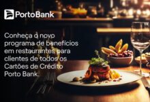 Mesa de restaurante com pratos e um cartão Porto Bank à vista, cena editorial em ambiente gastronômico